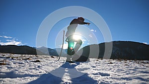 Happy man dances funny against the background of mountain landscape. Male tourist having fun during winter vacation or