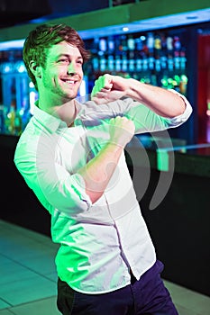 Happy man dancing in front of bar counter