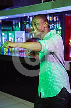 Happy man dancing in front of bar counter