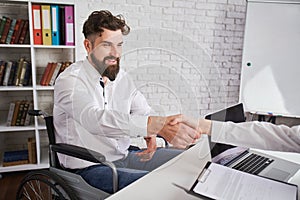 Happy man with disability shaking hands with HR