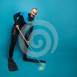 Happy man diver with mop on blue banner background. Clean and environmental protection concept