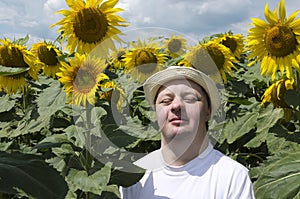 Happy man with doem syndrome enjoying sunny day in the sunflower field.Happy and joyful