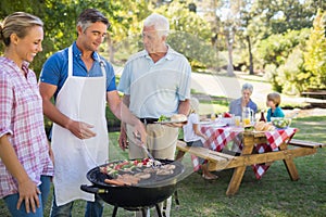 Happy man doing barbecue for his family