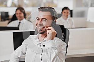 Happy man doing telemarketing in office