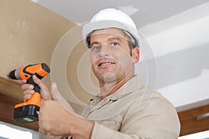Happy man drilling wall with drill perforator