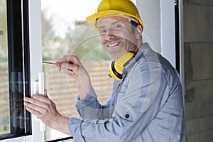 happy man drilling window frame
