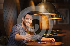 Happy man drinking beer at bar or pub