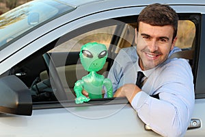 Happy man driving with an alien