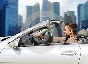 Happy man driving cabriolet car outdoors