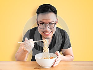 Happy man eating instant noodles.