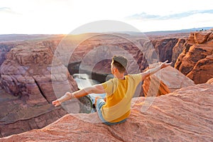 Happy man on the edge of the cliff. Horseshoe Bend Canyon in Page, Arizona. Adventure and tourism concept