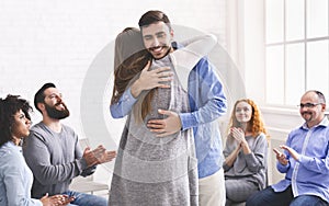 Happy Man Embracing Therapy Group Member After Treating Social Anxiety Disorder