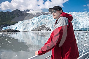 Happy man enjoys her boat tour to the glacier in Alaska, USA.