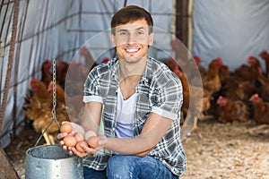 Happy man farmer holding fresh eggs