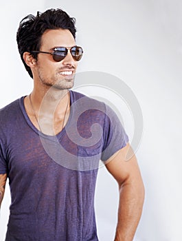 Happy, man and fashion with sunglasses on wall outdoor with confidence, cool style and pride. Summer, holiday and person