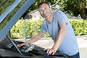 happy man fixing car photo