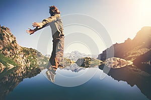 Happy Man Flying levitation jumping with lake and mountains on background