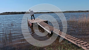 Happy man on footbridge near lake