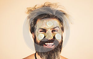 Happy Man with funny facial mask with Cucumber having fun. Procedure for applying mask from clay to face of funny man