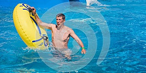 Happy man getting out of the swimming pool