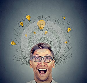 Happy man in glasses looking up with light idea bulb above head