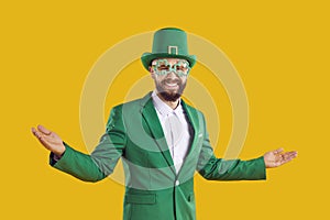 Happy man in green suit, hat and funny glasses welcomes you to St Patrick's Day Party