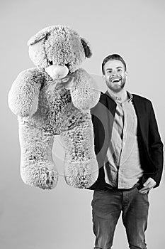 Happy man with grey teddy bear. Macho smile with big animal toy. Gift and present concept. Fashion and style. Birthday photo