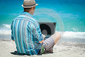 A Happy man guy with laptop near the seashore weekend travel