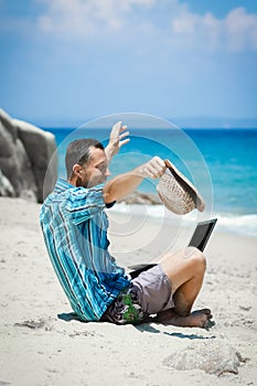 A Happy man guy with laptop near the seashore weekend travel