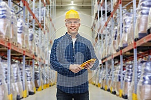 Happy man in hardhat with gloves over warehouse