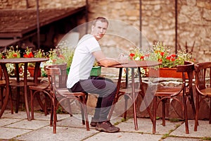 Happy man having coffee break at outdoors cafe in old europen city