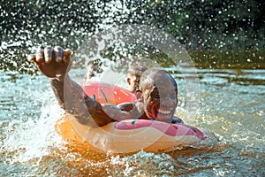 Happy man having fun, laughting and swimming in river