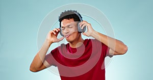 Happy man, headphones and dancing studio with music, radio or audio with energy on blue background. Listen, dancer and