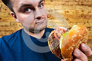 Happy man with his fast food burger. Not so much healthy life style, but whatever