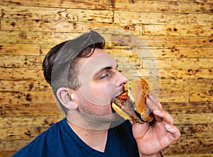 Happy man with his fast food burger. Not so much healthy life style, but whatever