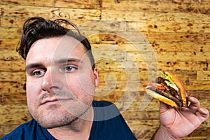 Happy man with his fast food burger. Not so much healthy life style, but whatever