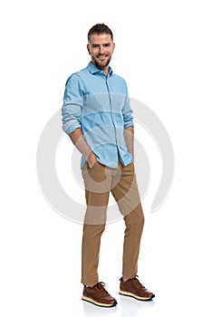 Happy man in his forties holding hands in pockets and smiling