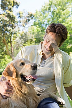Happy man with his pet dog in park