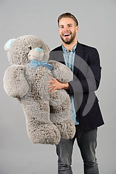 Happy man hold grey teddy bear. Macho smile with big animal toy. Thisi is for you. Gift and present concept. Birthday photo