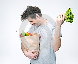 Happy man holding a bag full of groceries