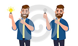 Happy man holding bright bulb and pointing index finger to it. Unhappy man holding dull bulb and pointing to it.