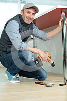 happy man holding cordless drill
