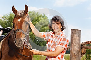 Happy man holding his beautiful horse by a bridle