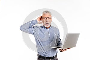 Happy man holding laptop computer and looking camera with opened mouth