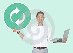 Happy man holding a laptop and a refresh icon