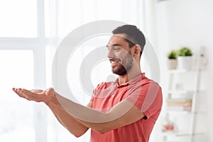 Happy man holding something imaginary at home
