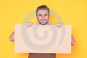 Happy man holds the sign, blank card. Placard ready for your product. Sign to your text. Smiling man showing blank sign