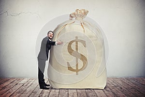 Happy man hugging a big bag of money