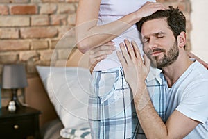 Happy man hugging pregnant wife