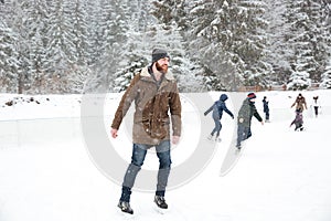 Happy man ice skating outdoors